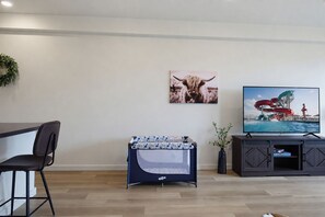 A living room with a sofa, a coffee table, a TV, and a wall-mounted picture.