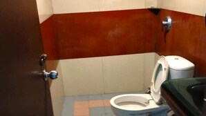 Ein kleines Badezimmer mit Toilette, Waschbecken und einer Tür.