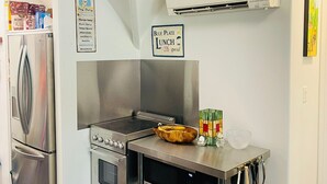 A compact kitchen with a built-in oven, a microwave, and a stainless steel refrigerator. - Upscale Parkside Living: Modern 1 bed & bath with All Utilities included (Columbus)