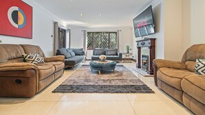 A living room with two sofas, a coffee table, a TV, and a fireplace. - Family 6 Bed | Gated Parking, Sleeps 11, Bray (Bray)