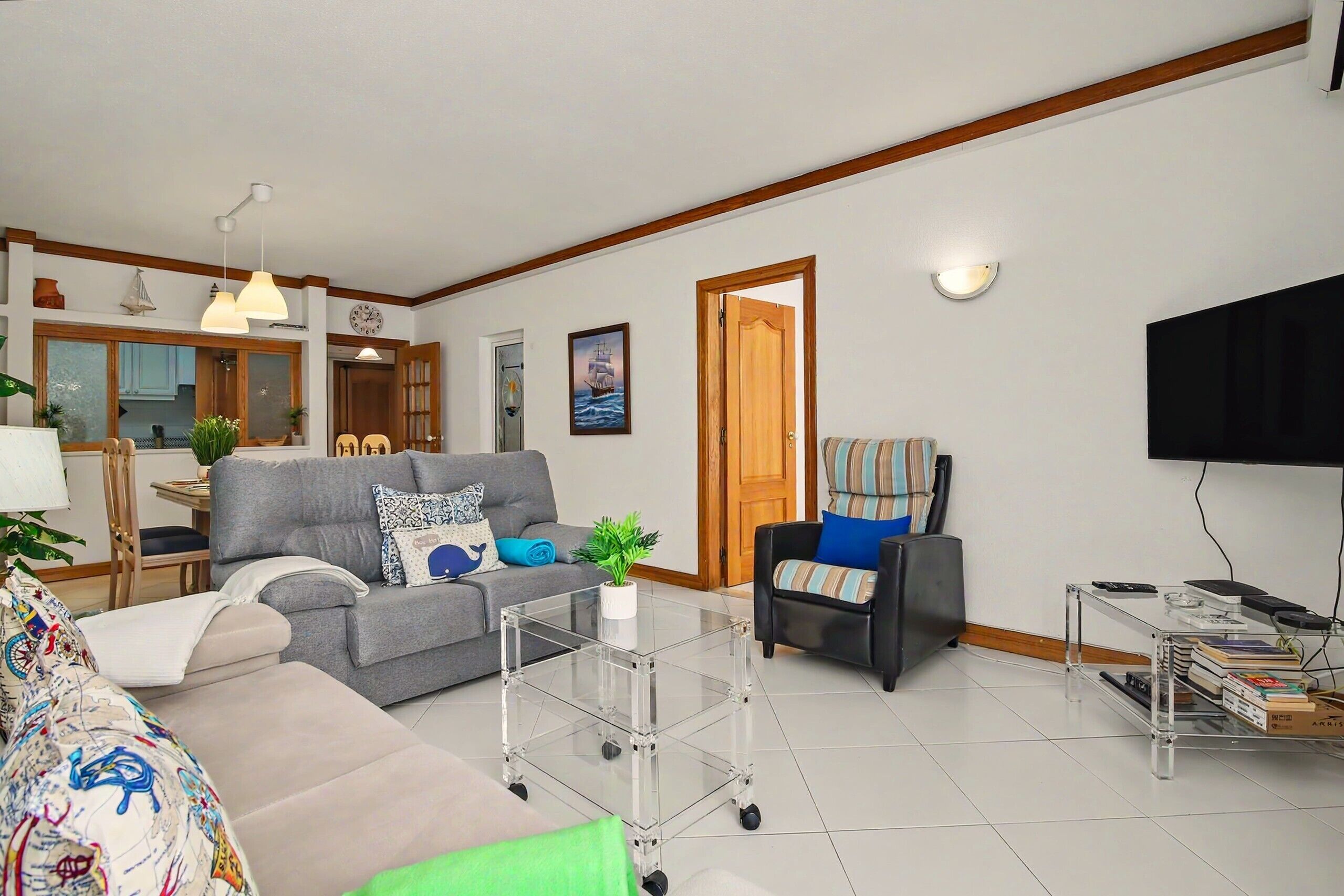 A living room with a sofa, a chair, a coffee table, and a TV.