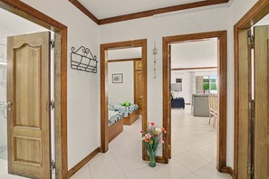 Ein Flur mit Holztüren, einer Treppe und einem Essbereich im Hintergrund.