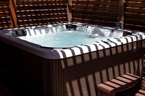 Een hottub met een houten buitenkant en een metalen kraan.