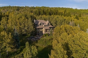 A large, multi-story house surrounded by dense forest. - Queen Bdrm | Private Bthrm | Balcony | Bragg Creek (Bragg Creek)