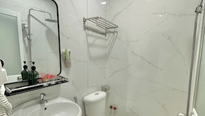 A bathroom with a sink, toilet, and shower. - Song Xanh Hotel  (Ho Chi Minh City)