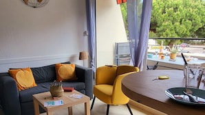 A modern living room with a sofa, a round table, and a chair. - Près du Rivage Méridien (Le Grau-du-Roi)