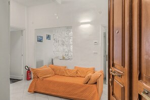 A room with a bed, a radiator, a fire extinguisher, and a door.