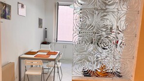 A dining area with a table, chairs, and a decorative glass partition.
