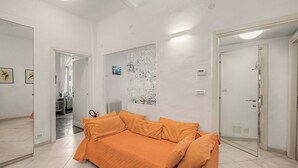 A room with a bed, a mirror, a radiator, and a door. - Apartment 'House Fede' with Sea View and Wi-Fi (Genoa)