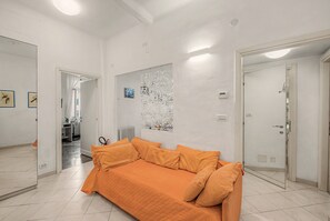 A room with a bed, a mirror, a radiator, and a door.