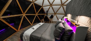 Un cuarto circular y acogedor con cama, escritorio y silla.