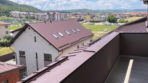 Un balcone con vista su edifici residenziali e un paesaggio verde.
