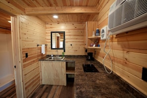A wooden cabin interior with a sink, mirror, and fan. - Glorious Lofted Cabin Perfect to Reconnect with Nature in South Dakota (Rapid City)