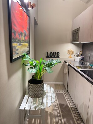 Una cucina con una pianta in vaso, un quadro incorniciato e un cartello con la scritta 'LOVE'.