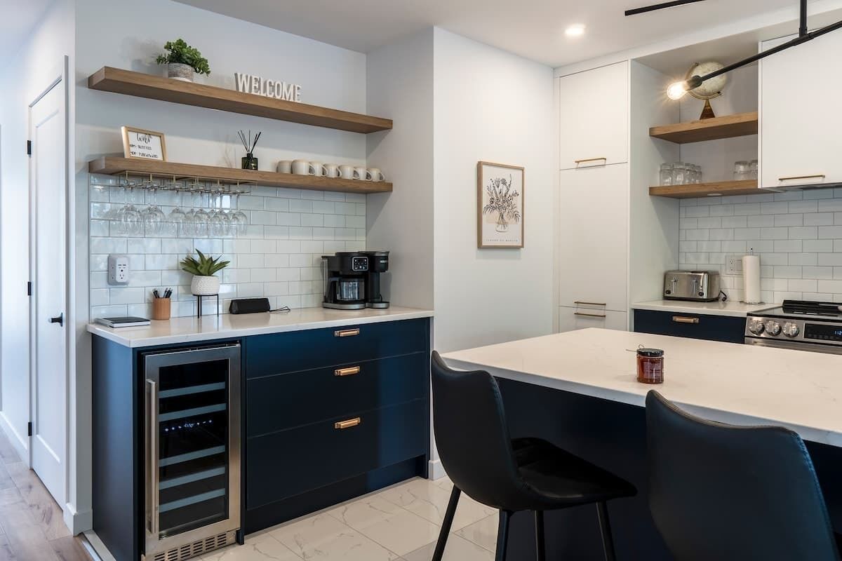 Una cocina moderna con una isla central, electrodomésticos integrados y un cartel acogedor.