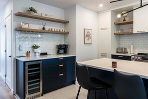 Una cocina moderna con una isla central, electrodomésticos integrados y un cartel acogedor.