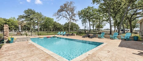 Una piscina rectangular con agua cristalina, rodeada por un patio de piedra.