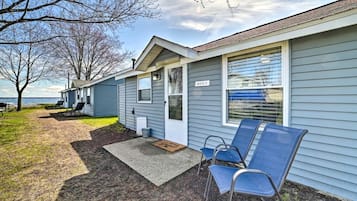 A single-story building with a front porch, a door labeled 'WOLF,' and a small outdoor seating area with two chairs.