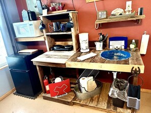 A kitchen with a wooden countertop, a coffee maker, a microwave, and various kitchen utensils. - Rustic Hill Country Cabin with Milky Way Stargazing & Wildlife Views near Mountain Home, TX (Mountain Home)