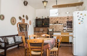 Eine Küche mit Backsteinwand, Holzmöbeln und einem weißen Kühlschrank.