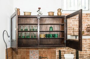 Eine Küche mit Holzschränken, grünem Glas und Kupferkochgeschirr.