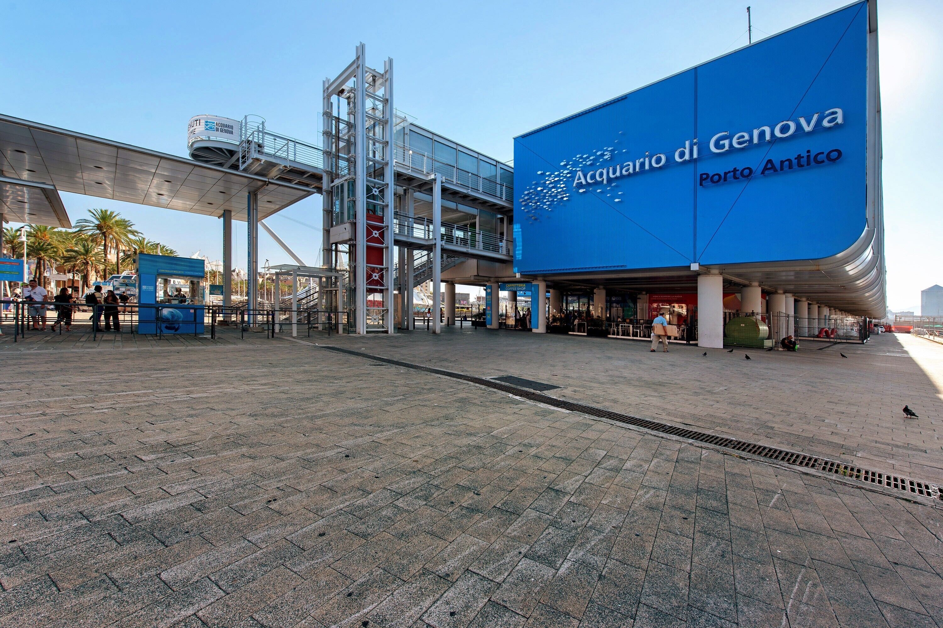 En modern byggnad med en framträdande blå skylt där det står ”Acquario di Genova Porto Antico”.