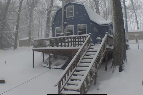 A house with a covered porch and a staircase leading to the entrance.