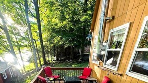 Une terrasse en bois avec des sièges d’extérieur, un lézard et un bâtiment doté de fenêtres.