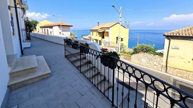 A residential street with a clear view of the sea, a paved walkway, and a metal railing. - At 211 Rooms Guest House (Room No. 5) (Pizzo)