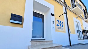 A building with a sign indicating '211 Rooms' and '2H' suggesting a hotel or lodging facility. - At 211 Rooms Guest House (Room No. 5) (Pizzo)