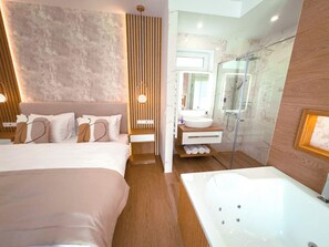 A modern hotel room with a large bed, a separate bathroom with a bathtub, and a shower. - Exclusive apartment in the center of Tihany with a two-person hot tub. (Tihany)