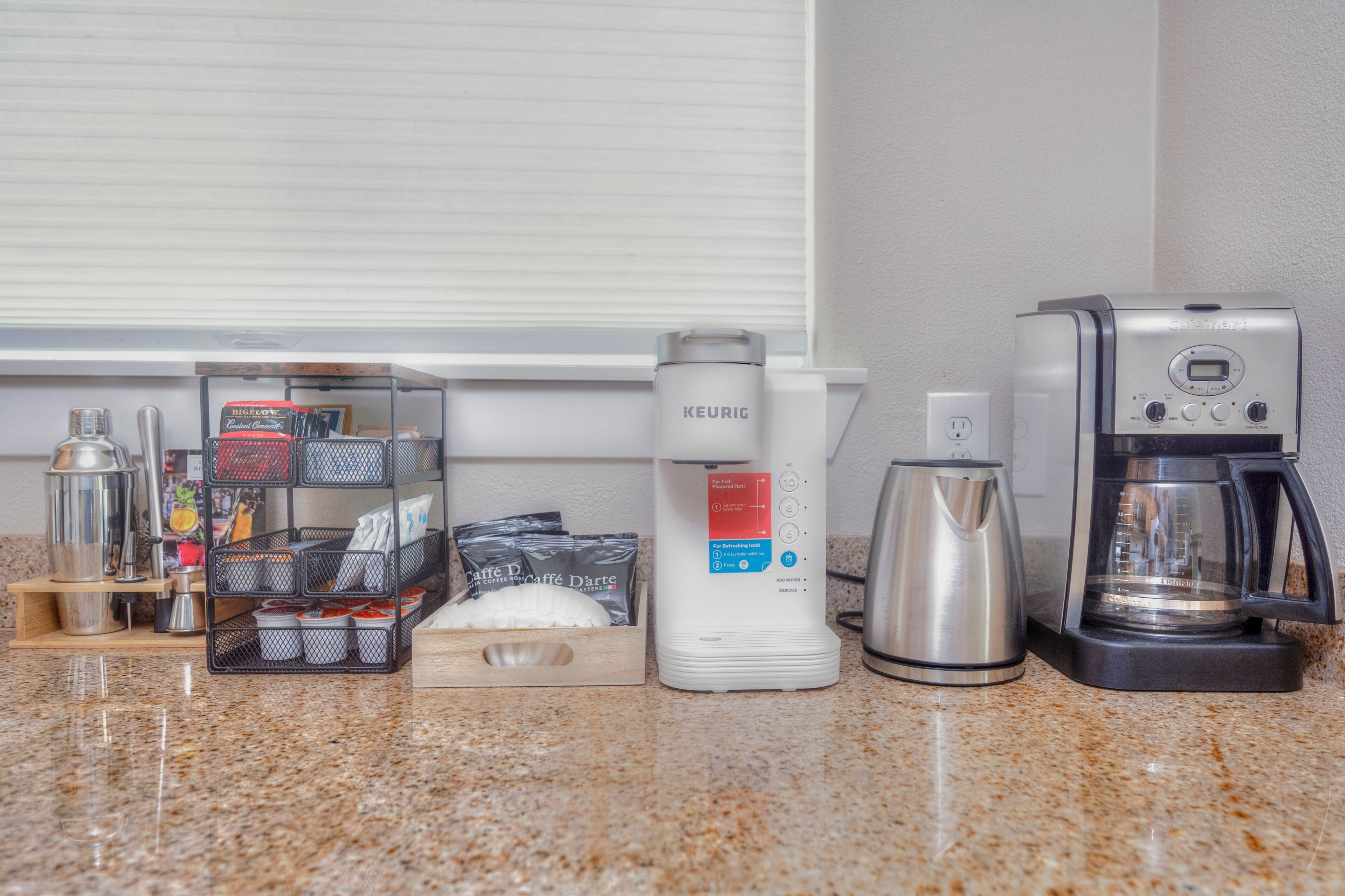 Eine Kaffeestation mit einer Keurig-Maschine, einer Kaffeemaschine und einer Kapselbox für Kaffee.