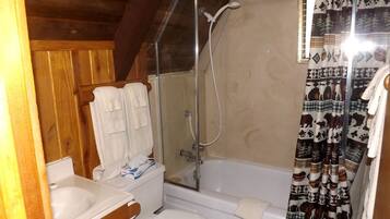 Un baño con ducha, inodoro y lavabo.