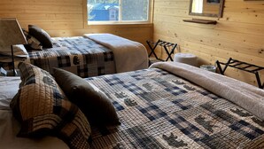 A cabin with two beds, a window, a ceiling fan, and a painting on the wall. - Amazing Spacious Barn near Yellowstone National Park, Idaho (Island Park)
