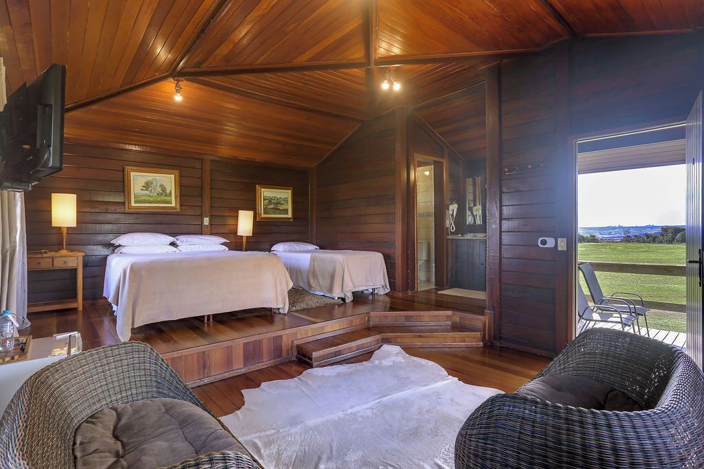 Uma cabana com duas camas, televisão e vista para o exterior.