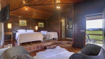 Una cabaña con dos camas, televisión y vistas al exterior.