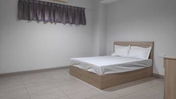A bedroom with a bed, a curtain, an air conditioning unit, and a tiled floor.