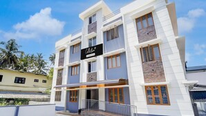 A multi-story building with a sign reading 'Collection & Company Serviced.' - Deluxe Tapas (Kozhikode)