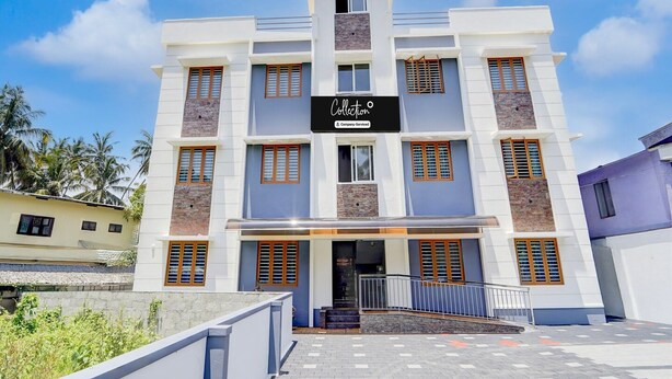 A multi-story building with a sign reading 'Collection Company-Serviced'. - Deluxe Tapas (Kozhikode)