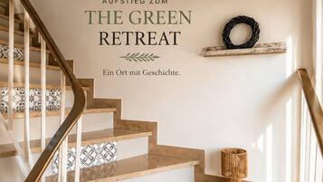 Eine Treppe mit einem hölzernen Geländer, beigen Stufen und dekorativen Fliesen.