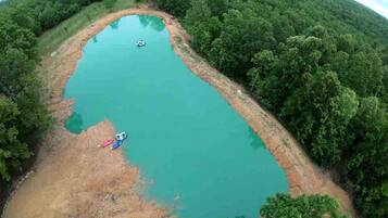 An aerial view of a natural lake surrounded by dense forest.