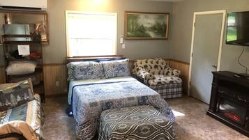 Une chambre à coucher avec un lit, une chaise, une cheminée et un tableau au mur.
