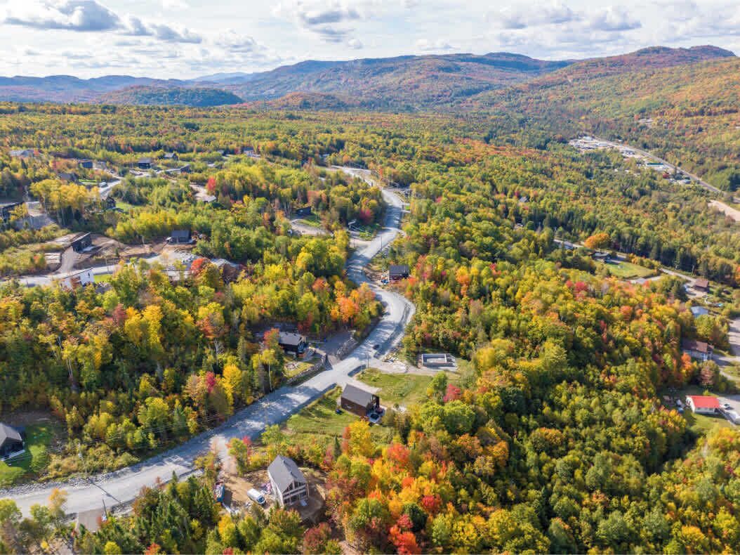 An aerial view of a residential area with houses, roads, and a river.