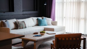 Un salon avec un canapé, une table basse et un fauteuil.