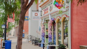 Une vue de rue avec un café appelé « Square Seven Coffee House », une enseigne indiquant une « galerie d’art » et une autre portant le nom « Michael W. Norris, Force aérienne de Lancaster ».