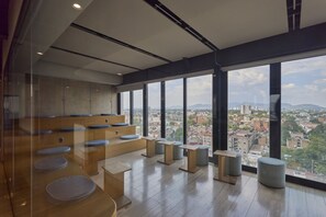 A modern interior with tiered seating and large windows offering a city view. - Studio in Anzures w/ Views, Gym & Jacuzzi (Ciudad de México)