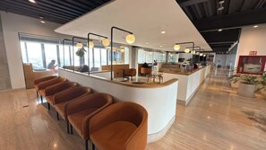 Ein modernes Interieur mit einer Rezeption, einer Lounge und großen Fenstern.