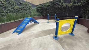 Ein Spielplatz mit einer blauen Rutsche und gelb-blauen Schutzvorrichtungen.