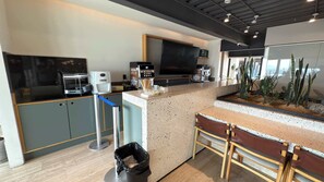 Eine moderne Küche mit Kaffeemaschine, Fernseher und einer Arbeitsplatte mit Pflanzenpräsentation.