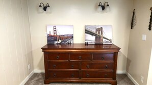 Een houten dressoir met zes lades en twee wandlampen erboven.